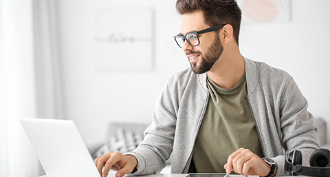 smiling man working on laptop in cozy home office three productivity tools